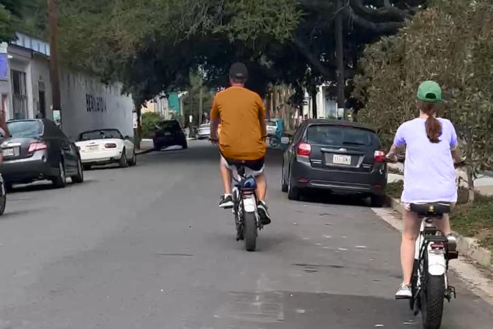 a person riding a bicycle down the street